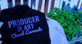 A black hoodie with blue and white text reading 'PRODUCER OF ART Cheval Lavande' draped over a light gray sweatshirt in an outdoor setting with a potted plant in the background.